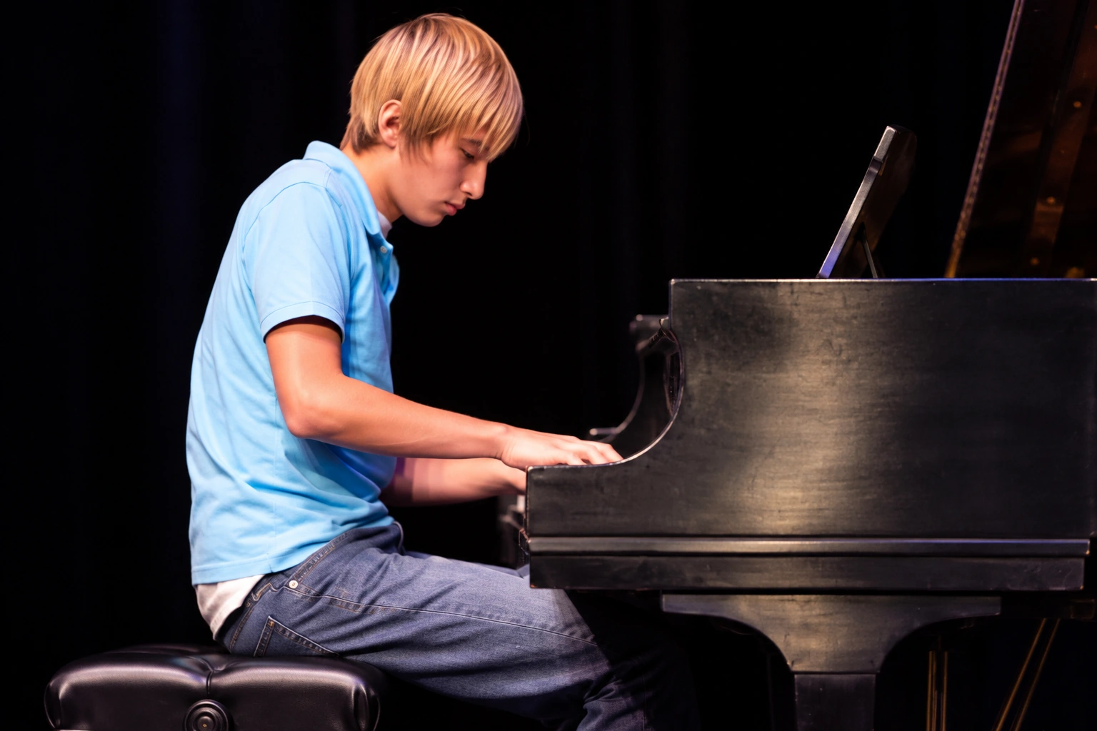 Pianist at a grand piano on stage · MBMS archive