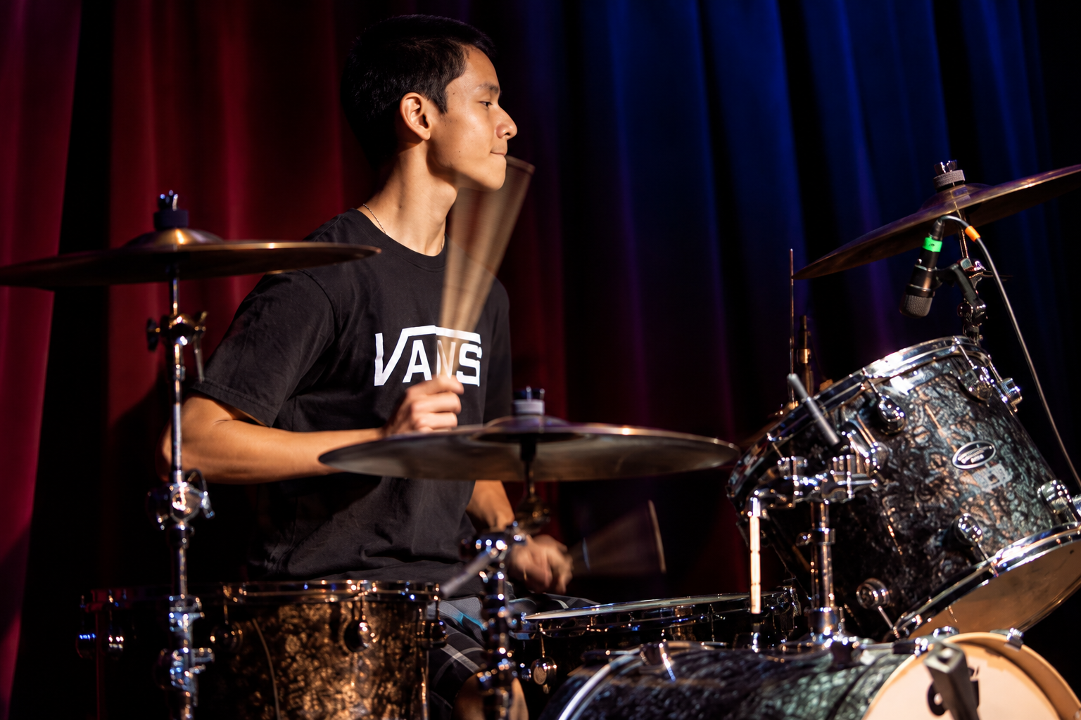 Drummer performing under stage lights · MBMS archive
