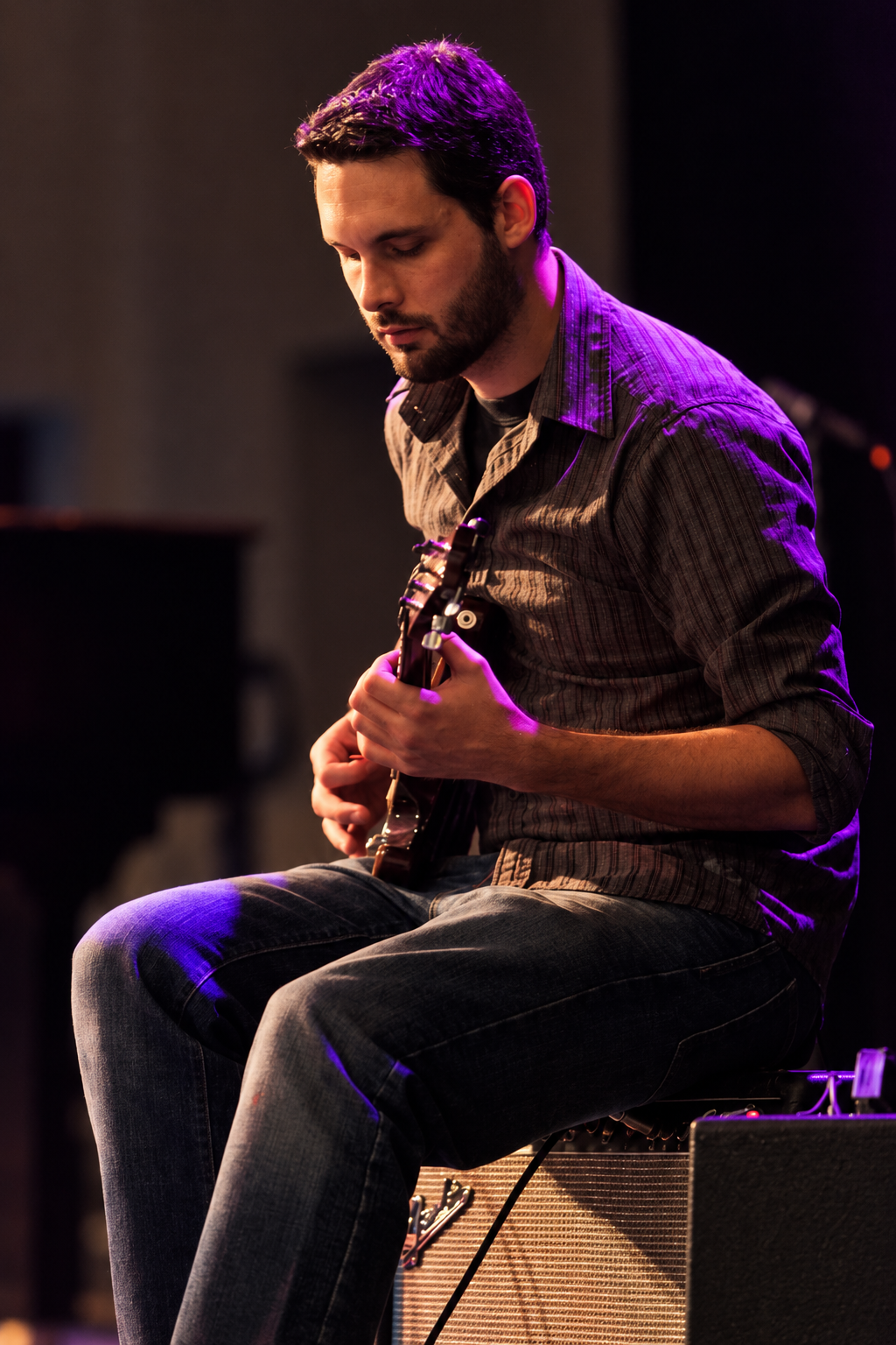 Seated guitarist performing · MBMS archive