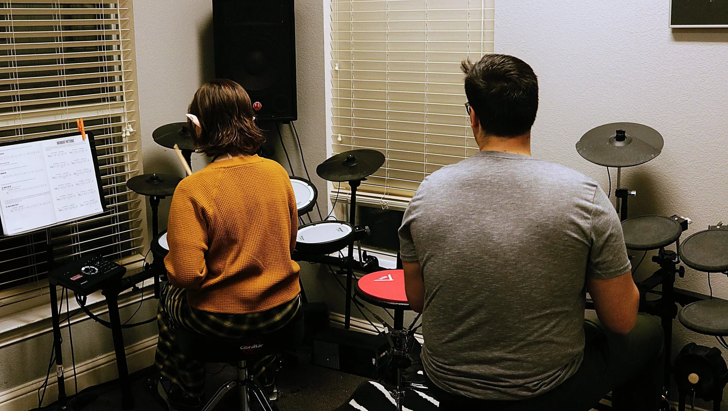 A student and instructor working together on drums